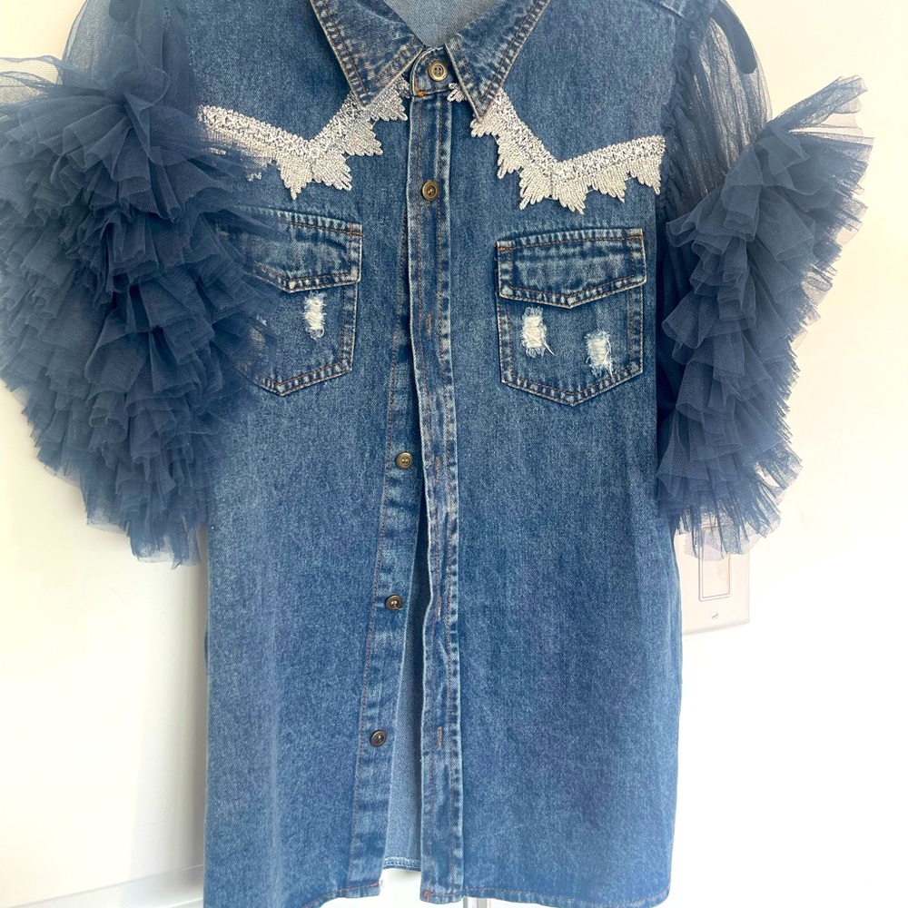 Denim blue ruffled button up shirt with metallic print on pockets.